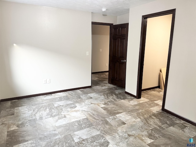 unfurnished room with a textured ceiling