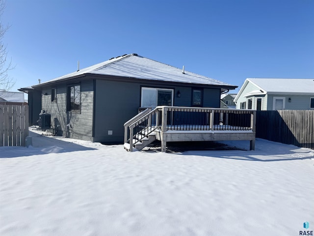 snow covered property featuring a wooden deck and central AC