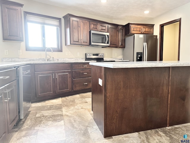 kitchen featuring dark brown cabinetry, sink, and appliances with stainless steel finishes