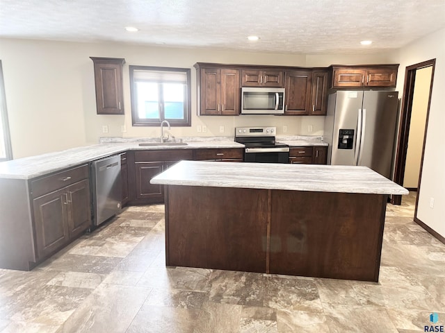 kitchen featuring stainless steel appliances, a kitchen island, sink, and dark brown cabinetry