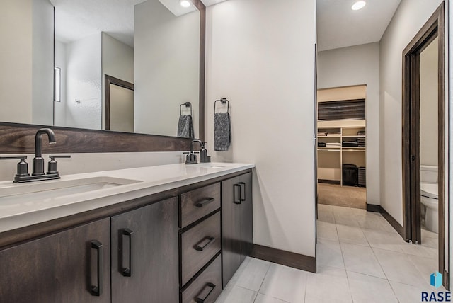 bathroom with tile patterned flooring, vanity, and toilet