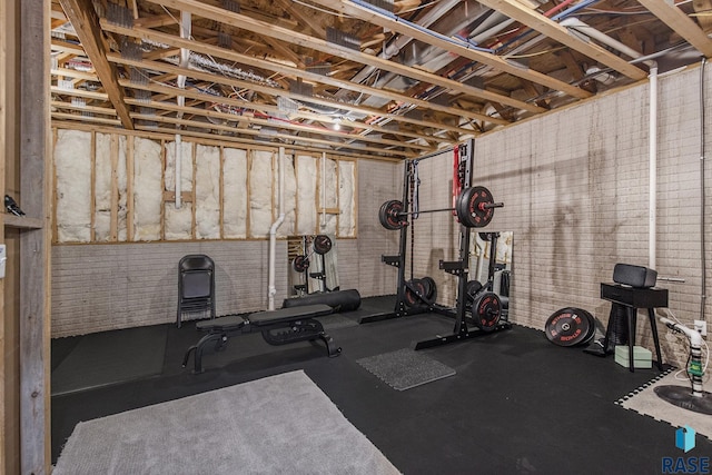 exercise room featuring brick wall