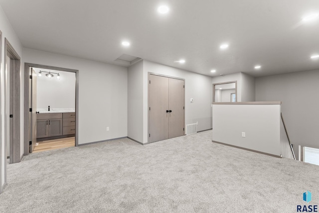 basement featuring light colored carpet