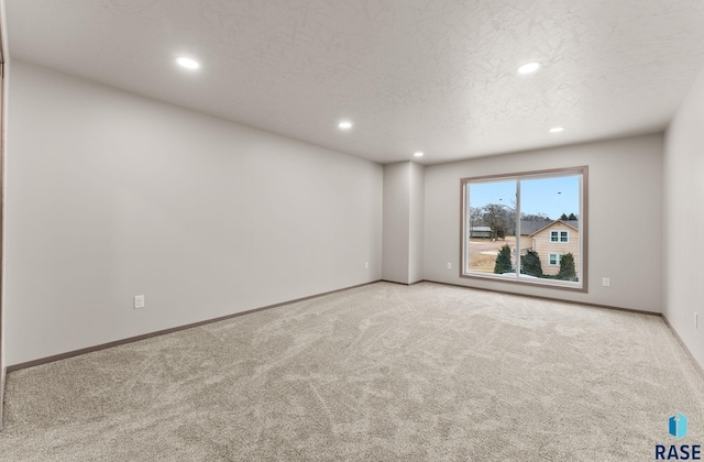 carpeted spare room featuring a textured ceiling