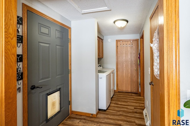 laundry room featuring cabinets, dark hardwood / wood-style floors, a textured ceiling, and independent washer and dryer