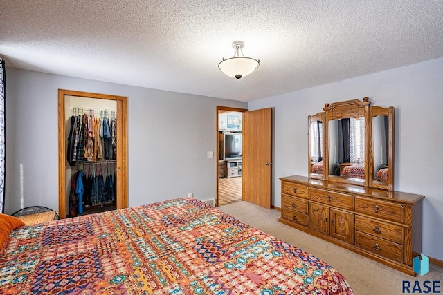 carpeted bedroom with a closet and a textured ceiling