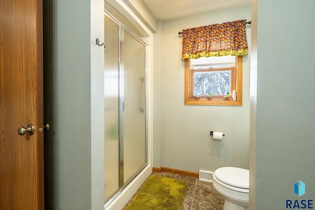 bathroom with walk in shower, toilet, and tile patterned flooring