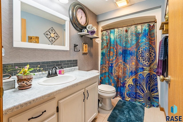 bathroom with tasteful backsplash, vanity, tile patterned floors, and toilet