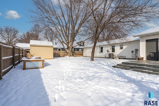 yard covered in snow featuring a shed