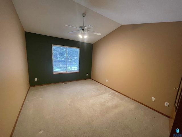 spare room with lofted ceiling, light colored carpet, and ceiling fan