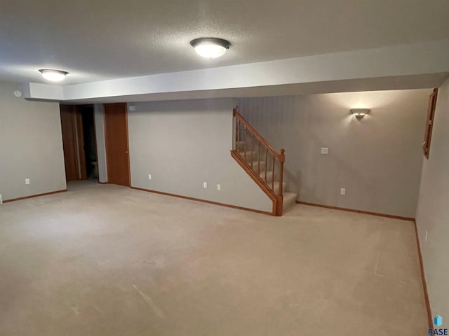 basement with light colored carpet and a textured ceiling