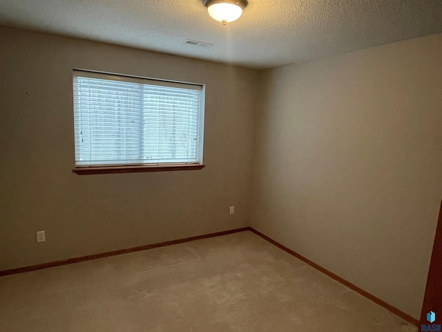 empty room featuring carpet and a textured ceiling