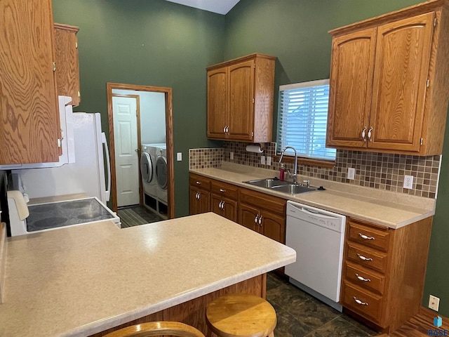 kitchen with separate washer and dryer, sink, range, white dishwasher, and kitchen peninsula