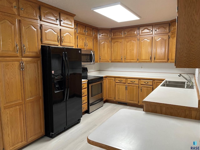 kitchen featuring sink, light hardwood / wood-style floors, and appliances with stainless steel finishes