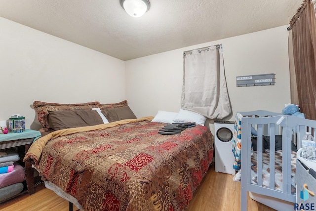 bedroom featuring a textured ceiling and light wood-type flooring