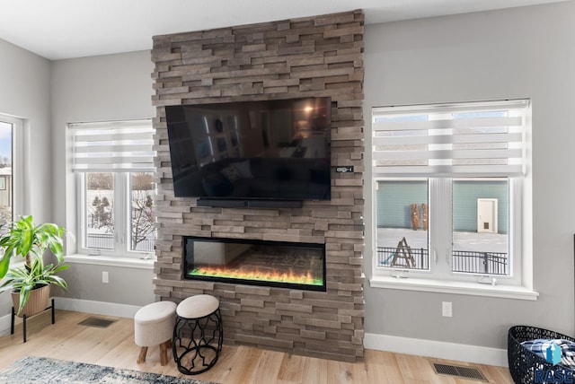 interior space featuring a stone fireplace and light wood-type flooring