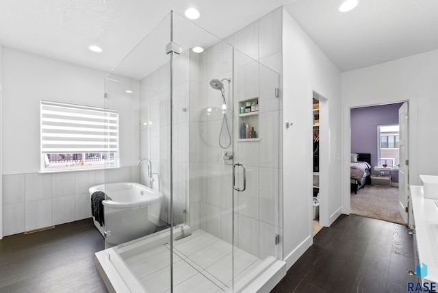 bathroom featuring wood-type flooring and separate shower and tub