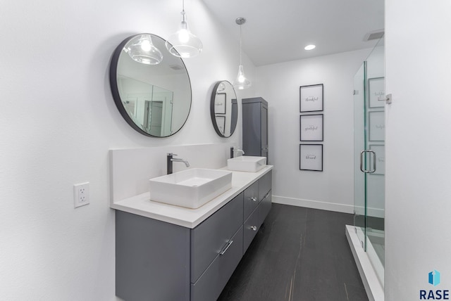 bathroom with hardwood / wood-style flooring, vanity, and a shower with shower door