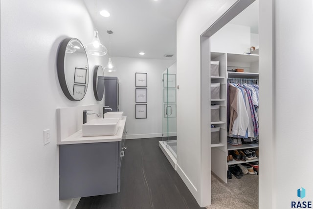 bathroom featuring vanity and a shower with door