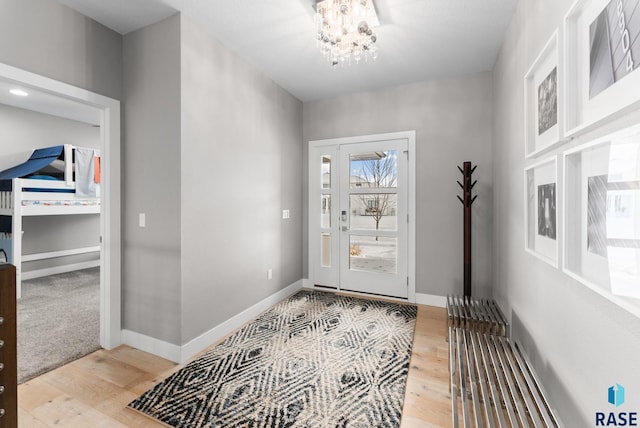 entryway featuring hardwood / wood-style flooring and a chandelier