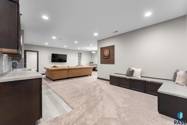 living room with sink and light carpet