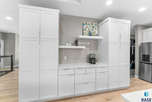 kitchen featuring white cabinetry, light hardwood / wood-style floors, and stainless steel fridge with ice dispenser