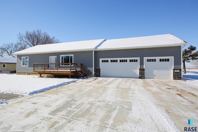 view of front facade featuring a garage, stone siding, and a wooden deck