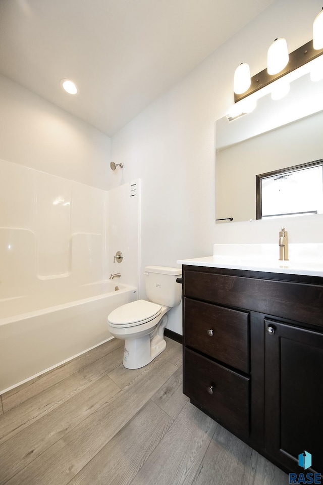 full bathroom featuring bathing tub / shower combination, toilet, vanity, and hardwood / wood-style floors