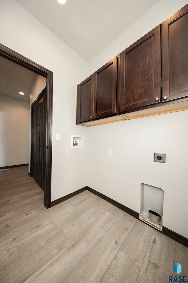 washroom with hookup for a washing machine, light hardwood / wood-style floors, hookup for an electric dryer, and cabinets