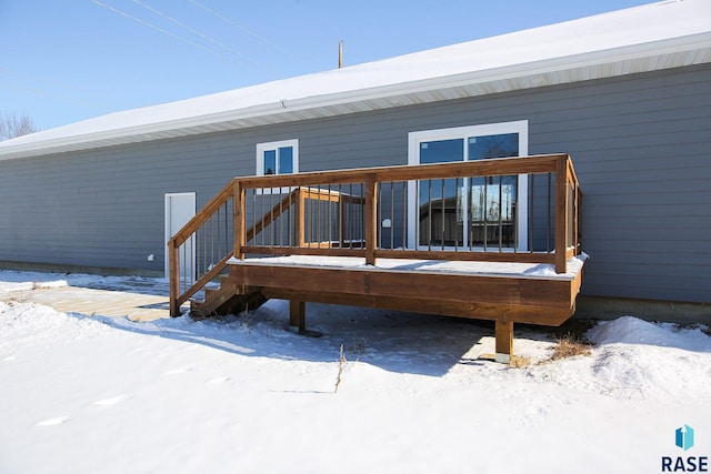 snow covered house featuring a deck