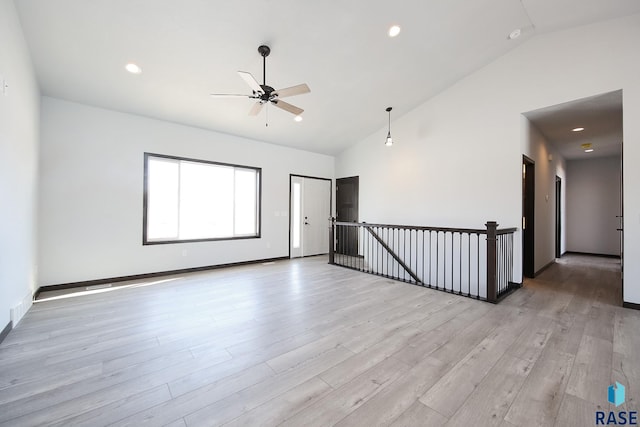 empty room featuring high vaulted ceiling, light hardwood / wood-style flooring, and ceiling fan