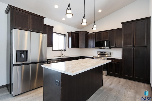 kitchen with hanging light fixtures, stainless steel appliances, vaulted ceiling, a center island, and sink