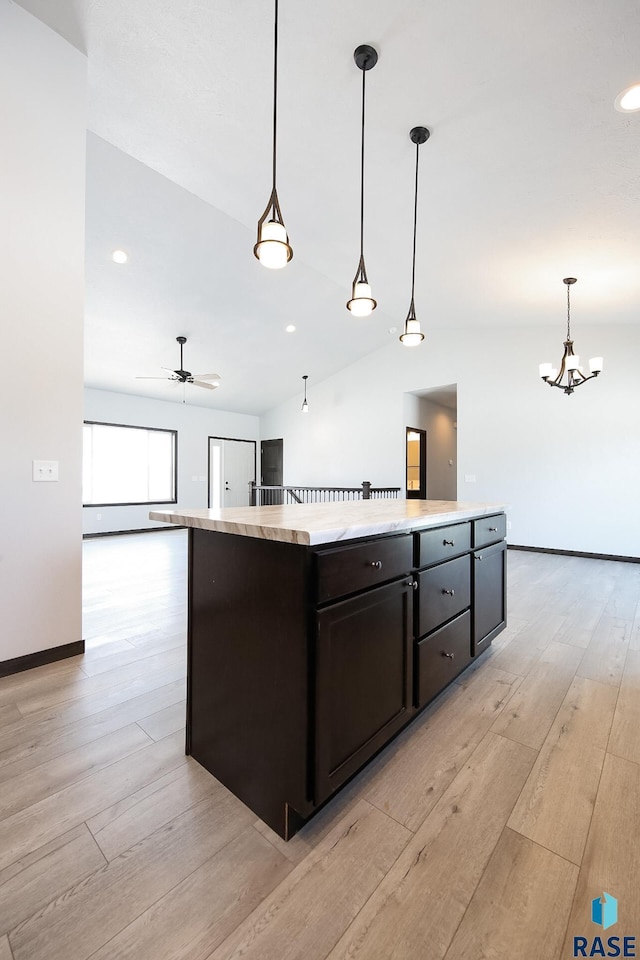 kitchen with hanging light fixtures, light wood-type flooring, lofted ceiling, and a kitchen island