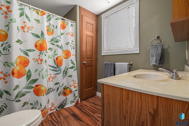 bathroom with walk in shower, vanity, toilet, and hardwood / wood-style floors