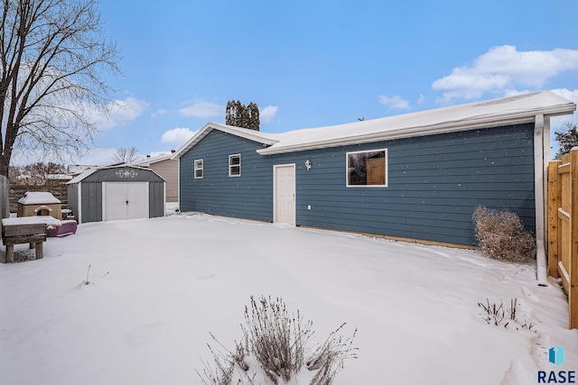 snow covered house with a storage shed