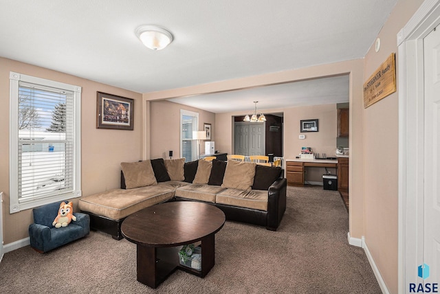 carpeted living room featuring a chandelier