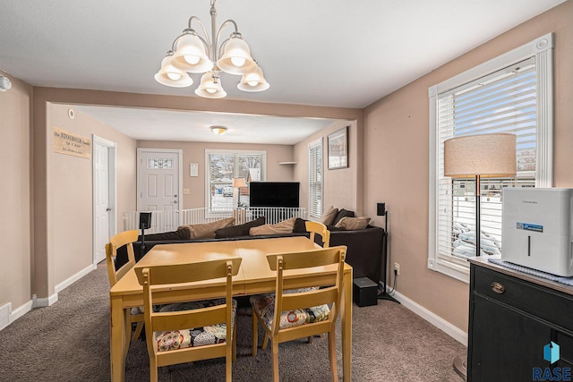 carpeted dining room featuring a notable chandelier