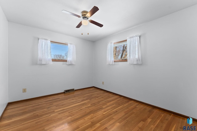 empty room with hardwood / wood-style flooring and ceiling fan