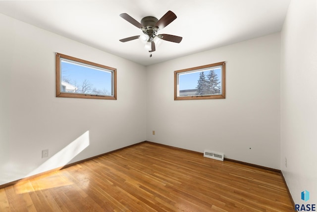 empty room with hardwood / wood-style flooring and ceiling fan