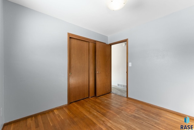 unfurnished bedroom with light hardwood / wood-style floors and a closet