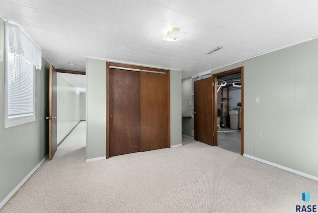 unfurnished bedroom featuring light carpet and a closet