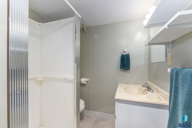 bathroom with vanity, tile patterned flooring, toilet, and walk in shower