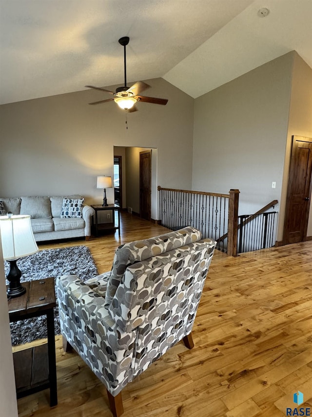 living room with hardwood / wood-style flooring, lofted ceiling, and ceiling fan