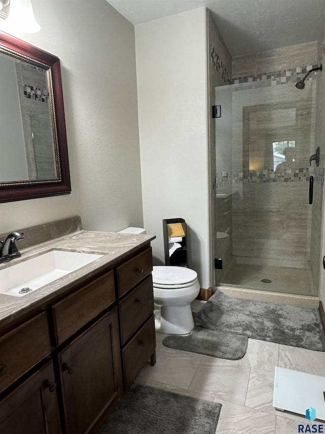 bathroom with walk in shower, vanity, and toilet