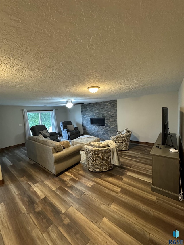 living room with a fireplace, dark hardwood / wood-style floors, and a textured ceiling