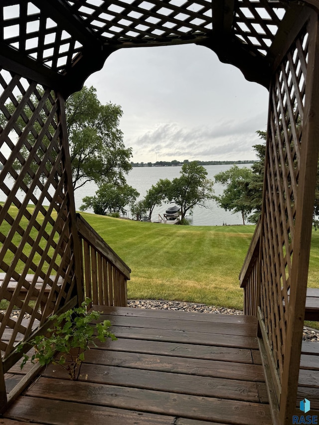 wooden deck featuring a water view and a yard