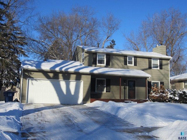 view of front of property featuring a porch, driveway, a chimney, and an attached garage