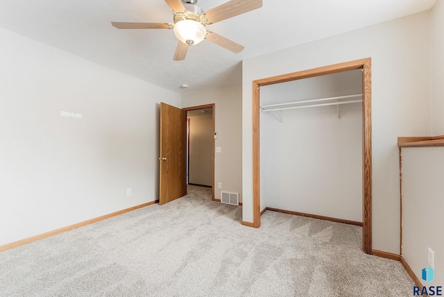 unfurnished bedroom featuring light carpet, a closet, and ceiling fan