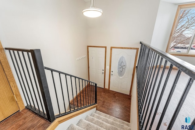 stairs with a towering ceiling and hardwood / wood-style floors