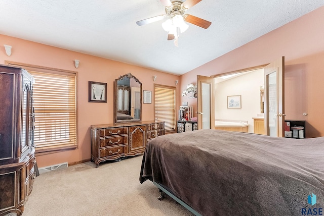 carpeted bedroom with ceiling fan, ensuite bathroom, vaulted ceiling, and a textured ceiling